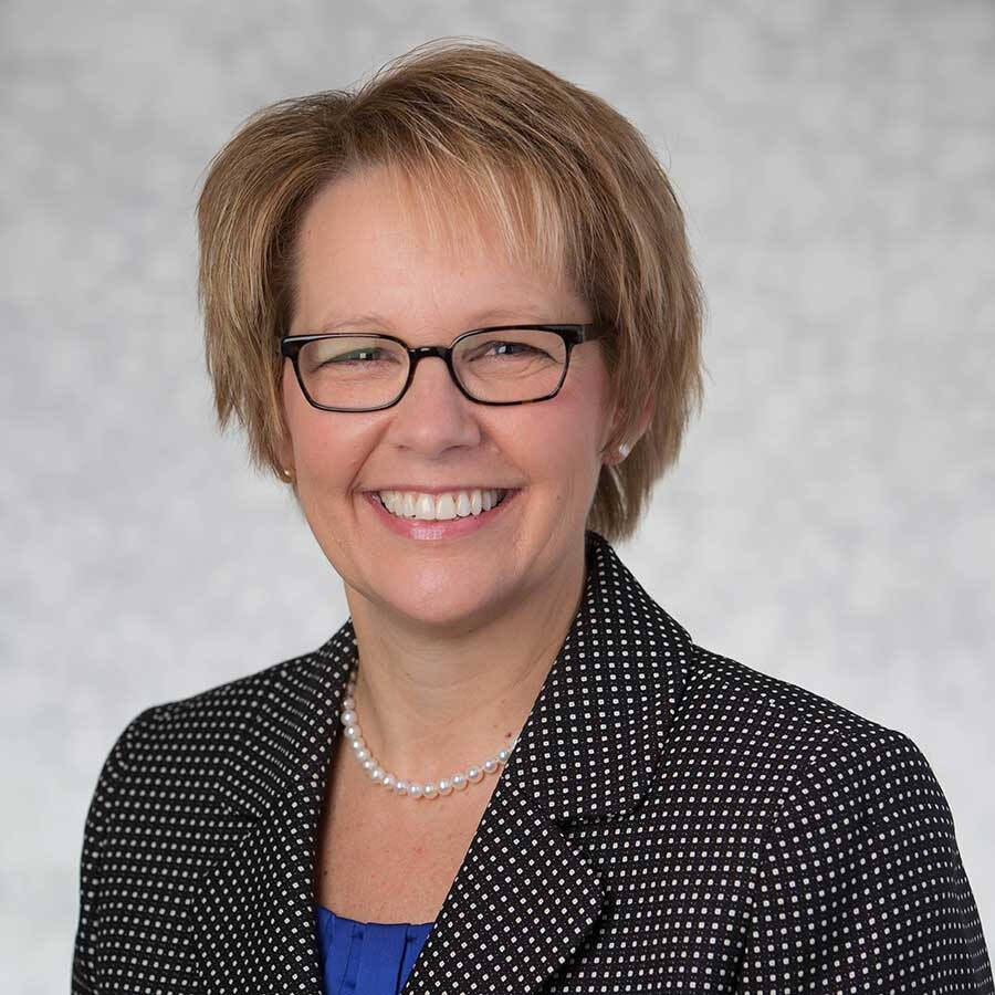 Mary Albrecht wearing a pearl necklace and a black polka dot suit jacket